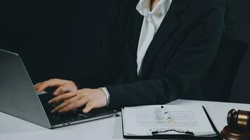 Business and lawyers discussing contract papers with brass scale on desk in office. Law, legal services, advice, justice and law concept picture with film grain effect video