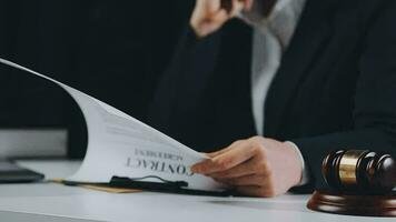 Business and lawyers discussing contract papers with brass scale on desk in office. Law, legal services, advice, justice and law concept picture with film grain effect video