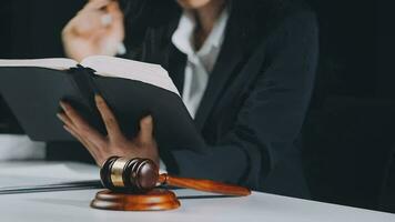 Business and lawyers discussing contract papers with brass scale on desk in office. Law, legal services, advice, justice and law concept picture with film grain effect video