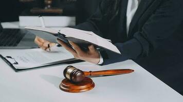 Business and lawyers discussing contract papers with brass scale on desk in office. Law, legal services, advice, justice and law concept picture with film grain effect video