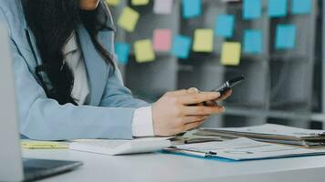 Young asian business woman working on project plan using sticky papers notes on glass wall, people meeting to share idea, Business design planning concepts. video