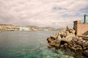 a view of the sea and a city from a rocky shore photo