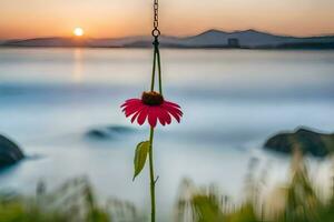 a pink flower hanging from a hook in front of the ocean. AI-Generated photo