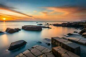 a beautiful sunset over the ocean with rocks and rocks. AI-Generated photo