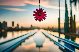 a pink flower hanging from a bridge over a river. AI-Generated photo