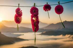 pink flowers hanging from a wire with mountains in the background. AI-Generated photo