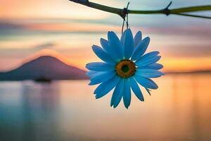 a blue flower is hanging from a branch in front of a lake. AI-Generated photo