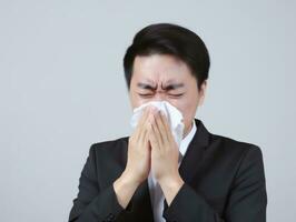Asian man is shown suffering from cold with runny nose on grey background AI Generative photo