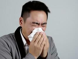 Asian man is shown suffering from cold with runny nose on grey background AI Generative photo