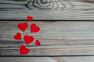 San Valentín día, pequeño y grande rojo corazón símbolo hermosa metido en un de madera mesa. tomar un de cerca y Seleccione enfocar, Copiar espacio en Derecha para diseño y texto. borroso antecedentes. foto