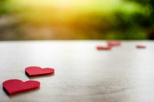 San Valentín día, un rojo corazón símbolo metido en un de madera mesa. tomar un de cerca y selectivo enfocar, Copiar espacio para diseño y texto. borroso antecedentes. foto