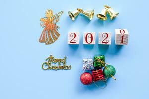 Top view and nobody. Wooden cube with word 2020 to 2021 New Year and Christmas Day concept on blue background. Closeup and copy space on left for design or text. photo