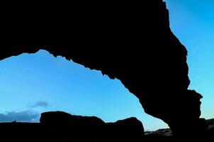 a silhouette of a rock formation photo