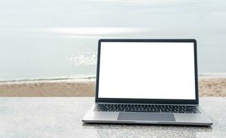 The Concept for business, technology, internet, design, and programmer. Blank white screen laptops are placed on a marble desk outdoor. Copy space on right Closeup, selective focus, blurred background photo