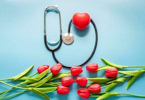 Greeting background. Happy nurse's day. Stethoscope, tulips, on blue background. Health day. National doctor's day. Top view, Closeup. Thank you, doctors and nurses photo