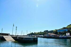 a boat dock in the water with a blue sky photo