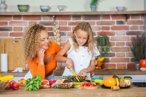 Happy mother and daughter are having fun in the kitchen. Healthy food concept. photo