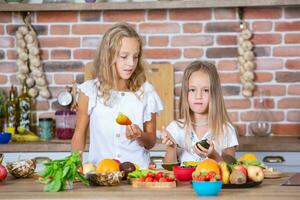 dos pequeño muchachas en el cocina con Fresco vegetales. sano comida concepto. contento hermanas foto
