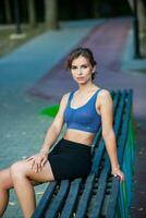 deportivo joven mujer en ropa de deporte haciendo extensión ejercicios al aire libre. retrato de un joven niña haciendo deporte en el parque. foto