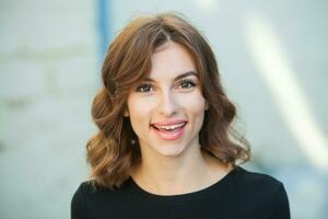 Portrait of a beautiful young woman with long brown hair smiling at the camera photo