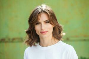 Portrait of a beautiful young woman with long brown hair smiling at the camera photo