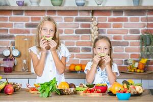 dos pequeño muchachas en el cocina con Fresco vegetales. sano comida concepto. contento hermanas foto