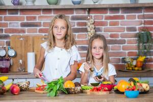 Mother and daughters cooking together in the kitchen. Healthy food concept. Portrait of happy family with fresh smoothies. photo