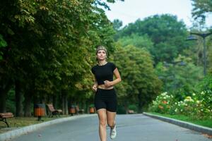 Sporty young woman in sportswear doing stretching exercises outdoors. Portrait of a young girl doing sport in the park. photo