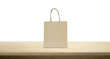 product packaging paper bag Empty paper bag mockup on wooden table isolated on white background. photo