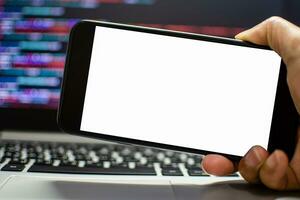 The developer wants to run an app on the smartphone device after coding from the IDE, the hand holding smartphone device the white screen, Take a close-up shot, blurred background, and clipping paths. photo