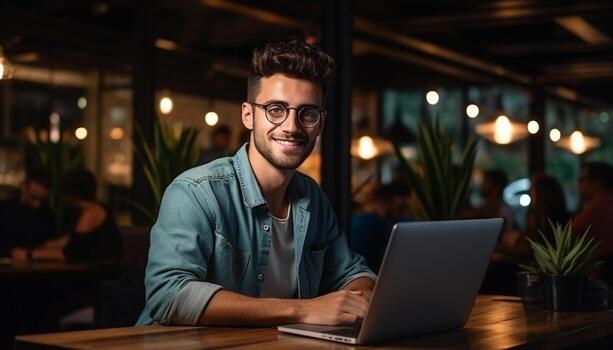 A young professional businessman sits at his desk, using his laptop computer to access the internet and work on business projects. generative ai photo