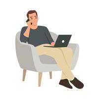 Young man working online from home, sitting in comfy armchair, using laptop and having phone conversation with business partner, copy space vector