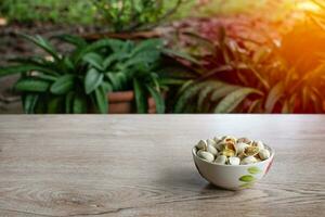 nuts in a cup on an old wood grain table left corner and take a closeup and slope view, right copyspace for text input, the photo is a landscape