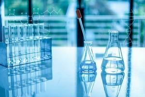 Chemistry experiment concept in science laboratory Two science flasks of different sizes contain different chemicals. The chemicals are in many glass tubes that are placed on the table and blurred. photo