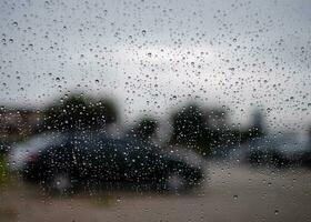 brillante gotas de lluvia en coche vaso, noche después trabajar, en el estacionamiento, tomar de cerca un imagen, negro-gris fondo, difuminar, paisaje, y hermosa imagen. foto