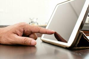 Close-Up, People using tablet search for food in the kitchen. A man with his finger touching a white tablet to learn cooking. Copy space, Blurred background photo