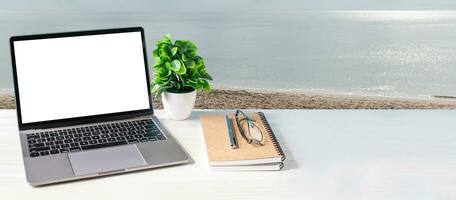 Blank and white screen laptop on a wooden table in the office. Working concept using technology, notebook, internet, laptop computer, network. Copy space on right for design, Closeup, blue background photo