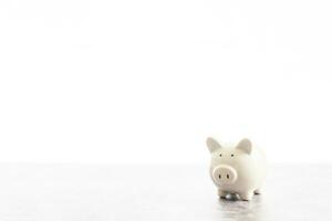 The white piggy bank placed on the cement floor Ideas for Finance Banking Savings Investing Marketing Closeup Copy space left for design or text. no one and white background photo