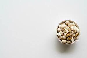 nuts in a cup on a white background lower right corner, take a closeup and top view, has left copy space for text input, the photo is a landscape