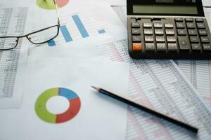 al accounting, Close-up calculator and numbers on paper, Many numbers, graph, glasses on paper, Documents placed on the table in the office, Blurred background. photo