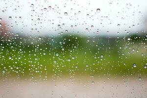 Bright raindrops on car glass, evening after work, in the parking, take close-up a photo,  Soil and grass background blur, image is the landscape and beautiful. photo