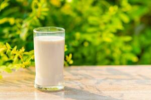 World Milk Day, Close up, Glass of white milk on a wooden desk, nature, blurred background. Happy Milk Day. Dairy product concept, copy space on right for design or text, nobody, World Milk Day 1 June photo