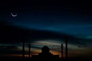 Concept the crescent moon the symbol of Islam begins the eid al Fitr. Seeing the moon in the night sky. The evening sky and the vast river in darkness are beautiful. photo