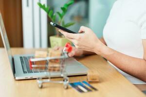 woman hand holding credit card and using laptop with mobile phone for online shopping while making order. Marketplace platform website, technology, ecommerce, shipping delivery and online payment photo