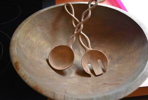 Carved and Crossed Wooden Salad Tongs in a Bowl photo