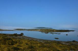 Tranquil Coastal Views with Fog Clouds Hovering Over the Water photo