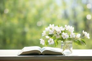 jazmín flores en un florero y abierto libro en el mesa, verde natural antecedentes. ai generado foto