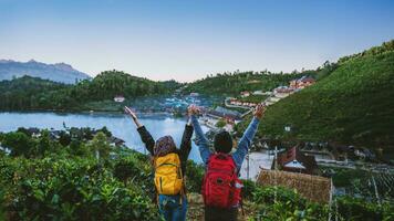 Couple Asian traveling together on mountain in Ban Rak Thai village countryside. Travel, camping in the winter, Outdoor relaxation, Romantic couples. photo