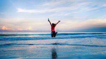 Girl running workout jogging on the beach in the morning. relax and happy with running on the sea. in summer photo