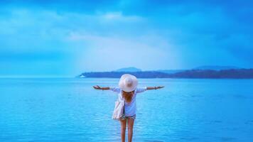 Asian woman travel nature. Stand relax on the beach. In the summer photo